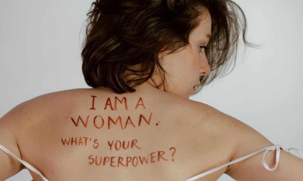 Back view of woman with empowering message, promoting self-love and feminism.